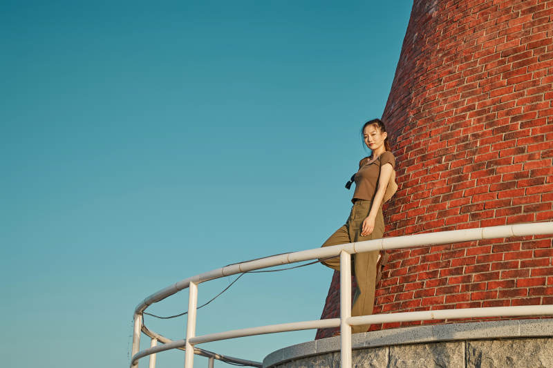 盛夏夕阳晚霞湖边码头灯塔上的少女图片