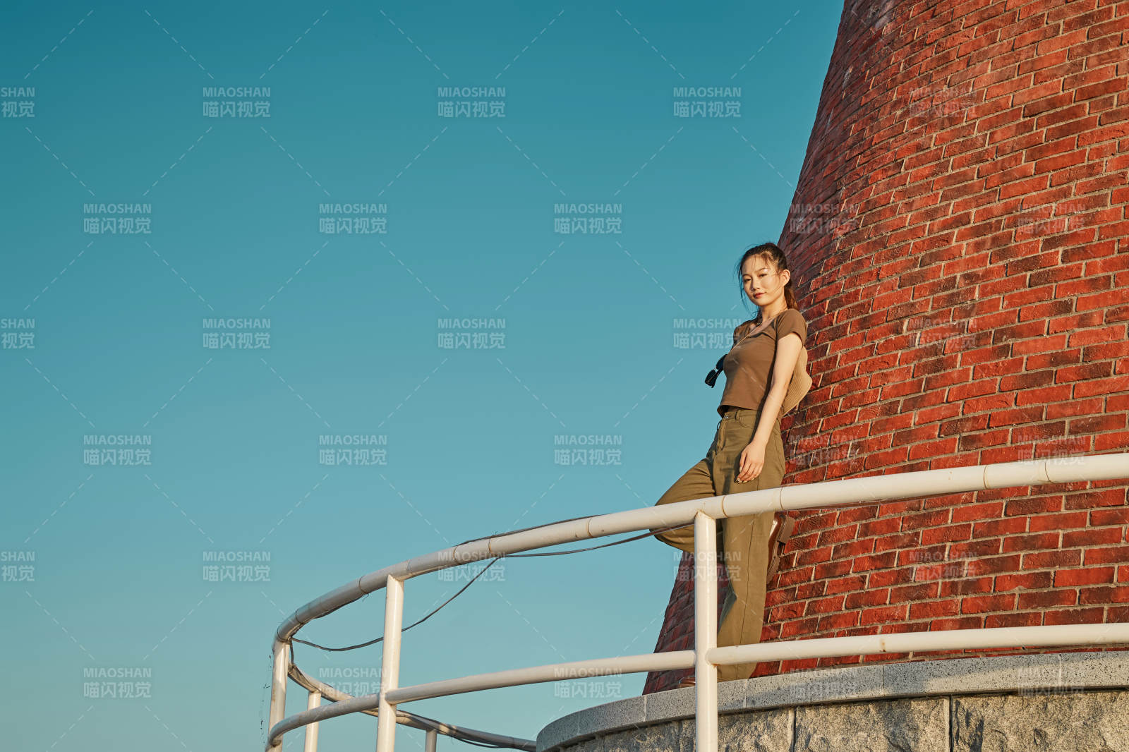 盛夏夕阳晚霞湖边码头灯塔上的少女图片