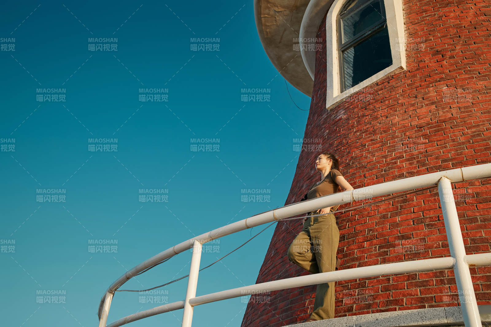 盛夏夕阳晚霞湖边码头灯塔上的少女图片