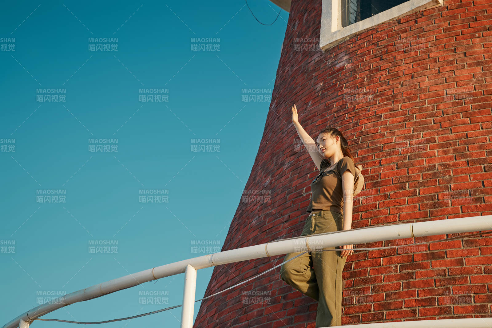盛夏夕阳晚霞湖边码头灯塔上的少女图片