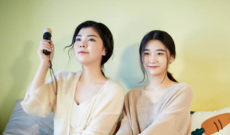 坐在床上打电玩的俩位美女图片