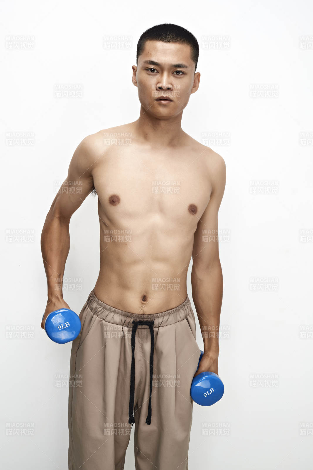 使用哑铃进行健身锻炼的亚洲男性图片