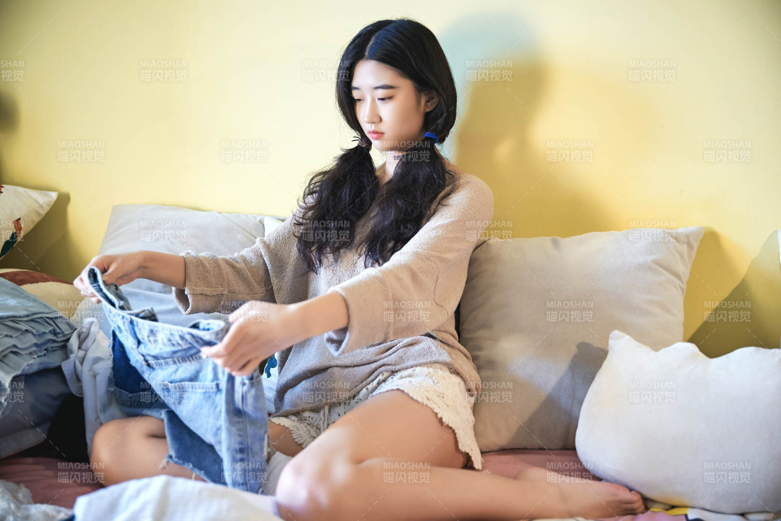 在沙发床上整理行装的年轻亚洲女性图片