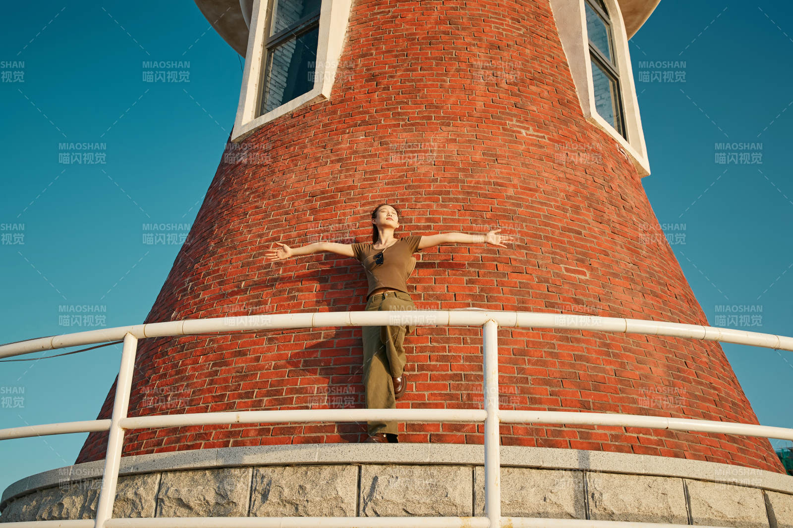盛夏夕阳晚霞湖边码头灯塔上的少女图片