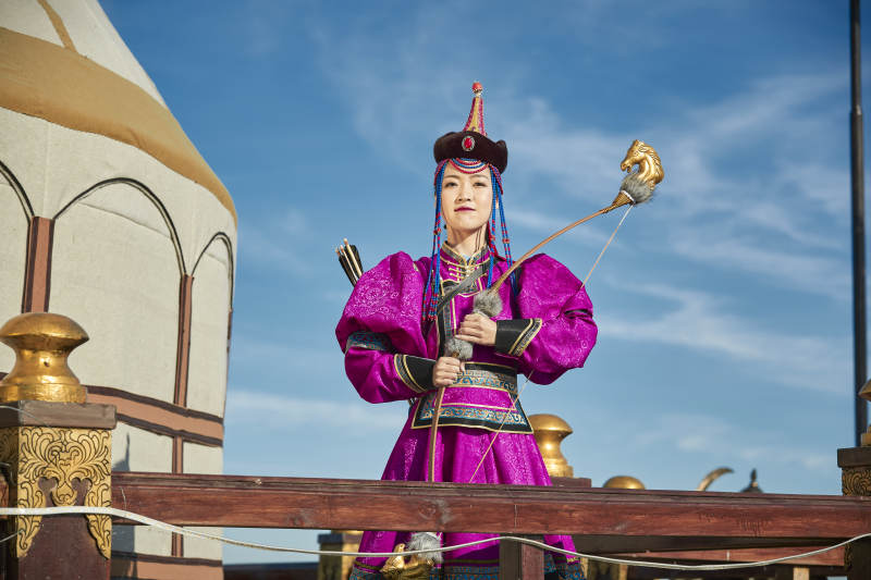 蒙古包前身穿蒙古族饰手持弓箭的蒙族少女图片