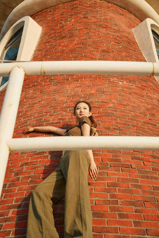 盛夏夕阳晚霞湖边码头灯塔上的少女图片