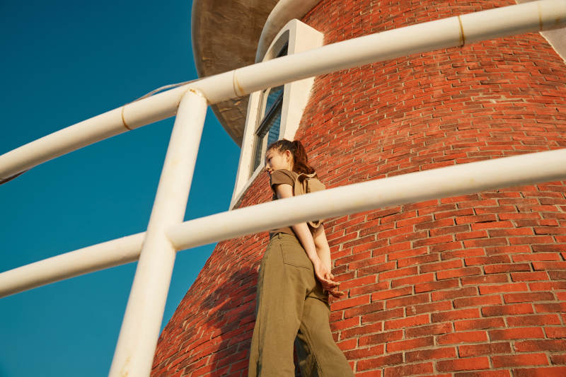 盛夏夕阳晚霞湖边码头灯塔上的少女图片