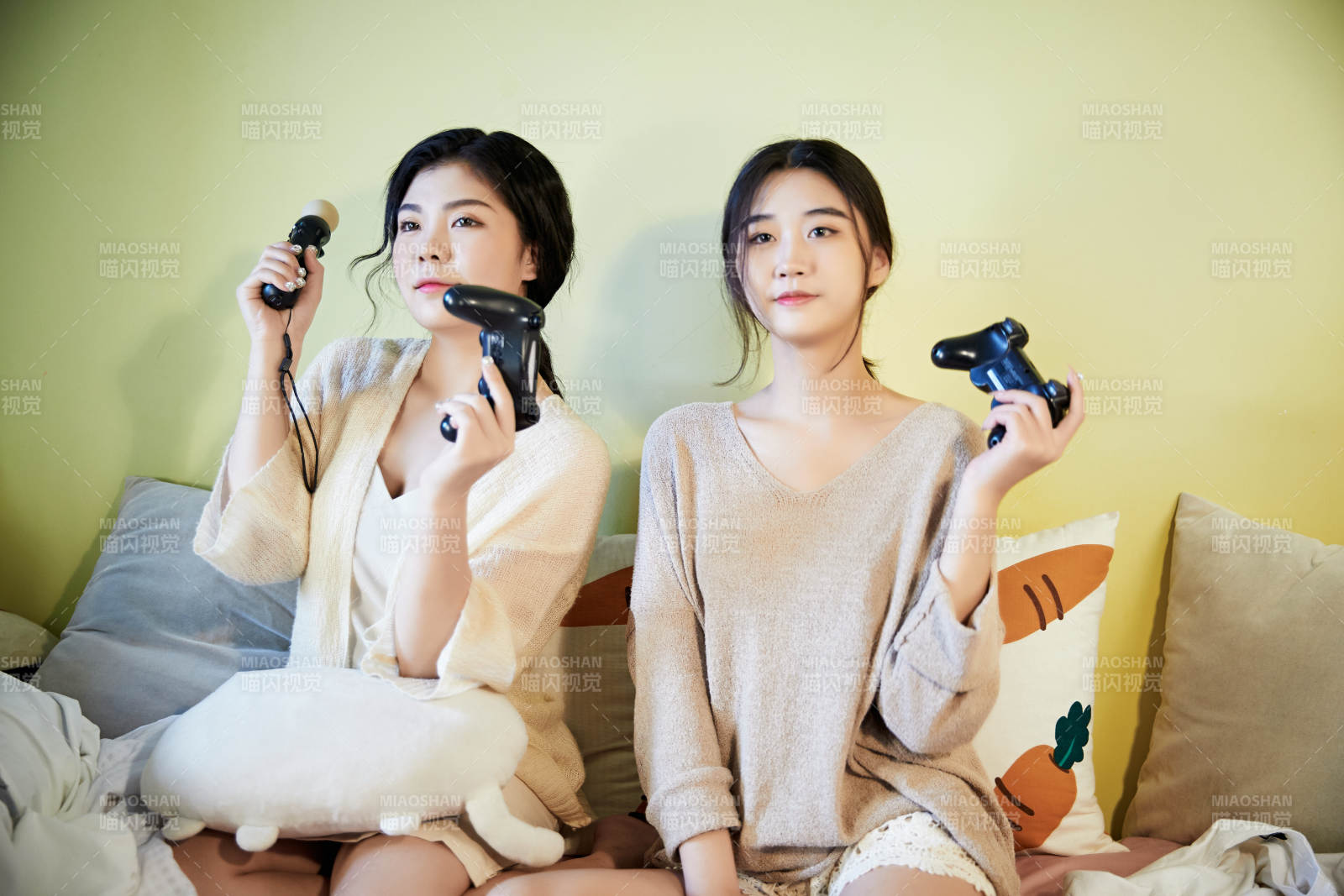 坐在床上打电玩的俩位美女图片