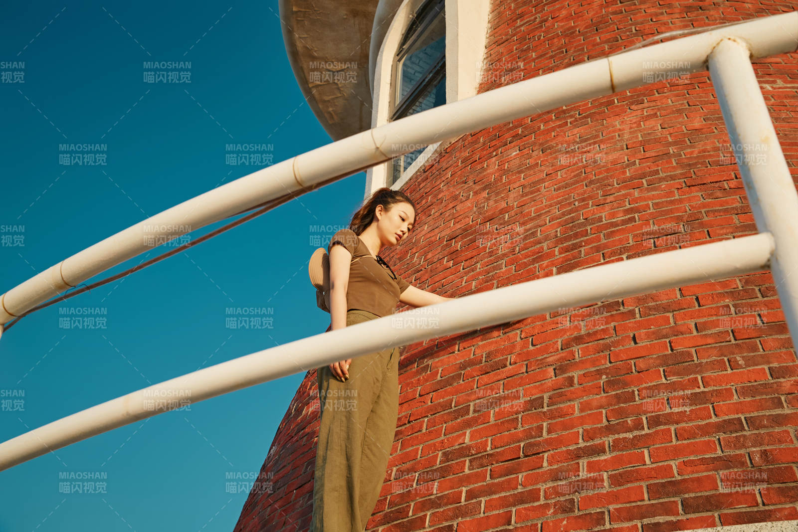 盛夏夕阳晚霞湖边码头灯塔上的少女图片