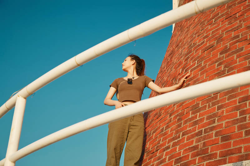 盛夏夕阳晚霞湖边码头灯塔上的少女图片