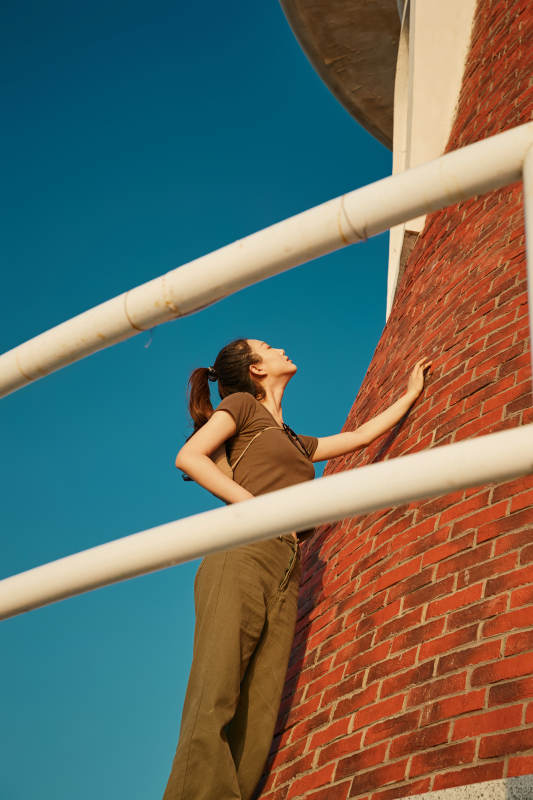 盛夏夕阳晚霞湖边码头灯塔上的少女图片