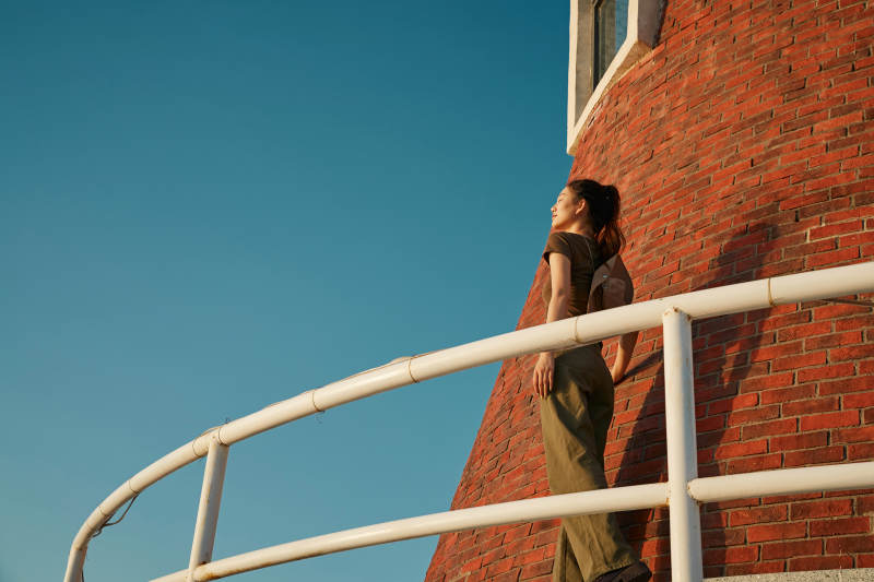 盛夏夕阳晚霞湖边码头灯塔上的少女图片