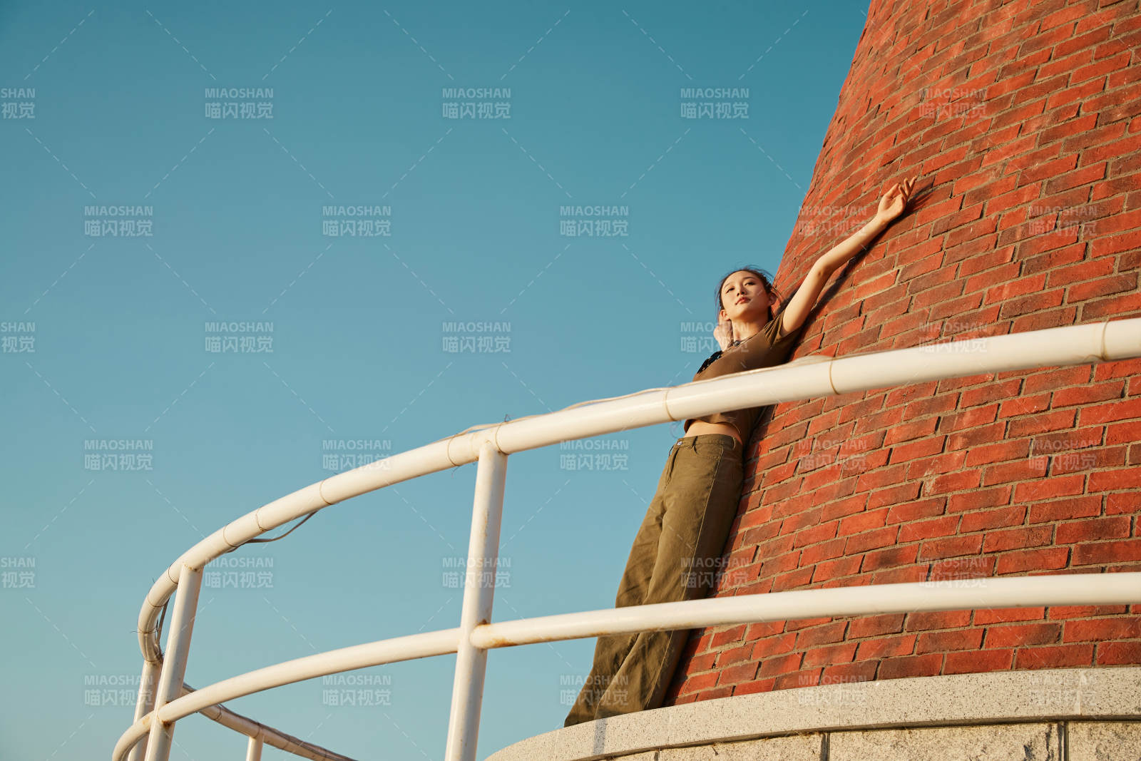 盛夏夕阳晚霞湖边码头灯塔上的少女图片