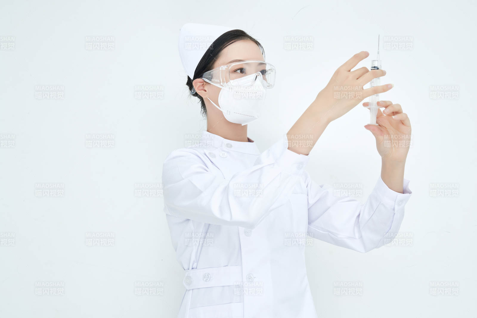 穿护士服戴口罩手执针筒的年轻女护士图片