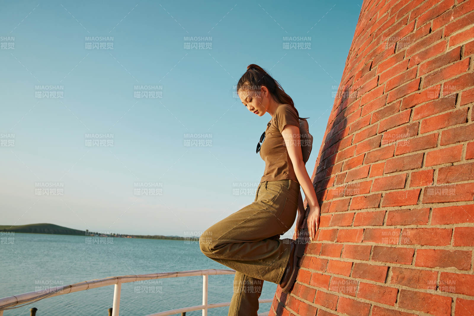 盛夏夕阳晚霞湖边码头灯塔上的少女图片