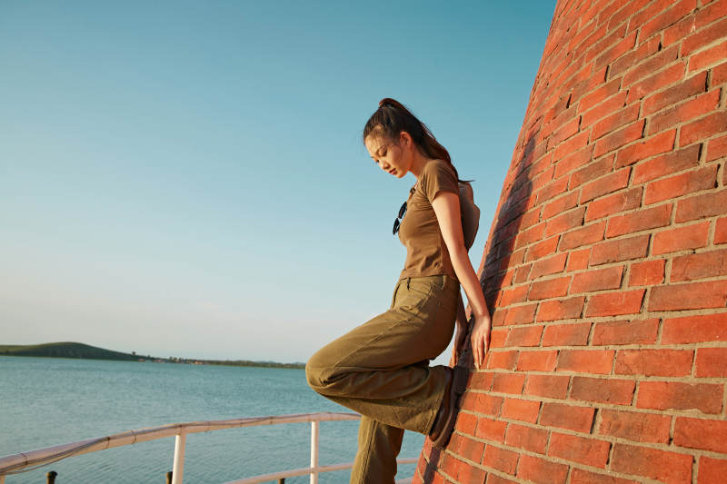 盛夏夕阳晚霞湖边码头灯塔上的少女图片