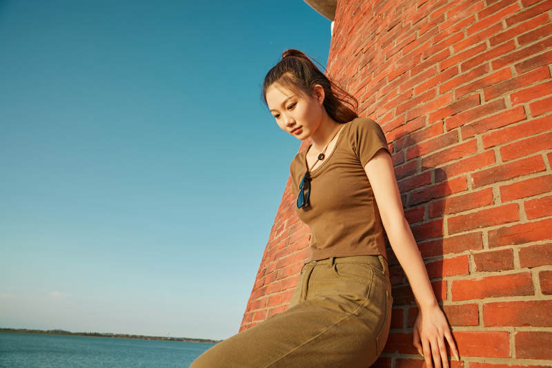 盛夏夕阳晚霞湖边码头灯塔上的少女图片