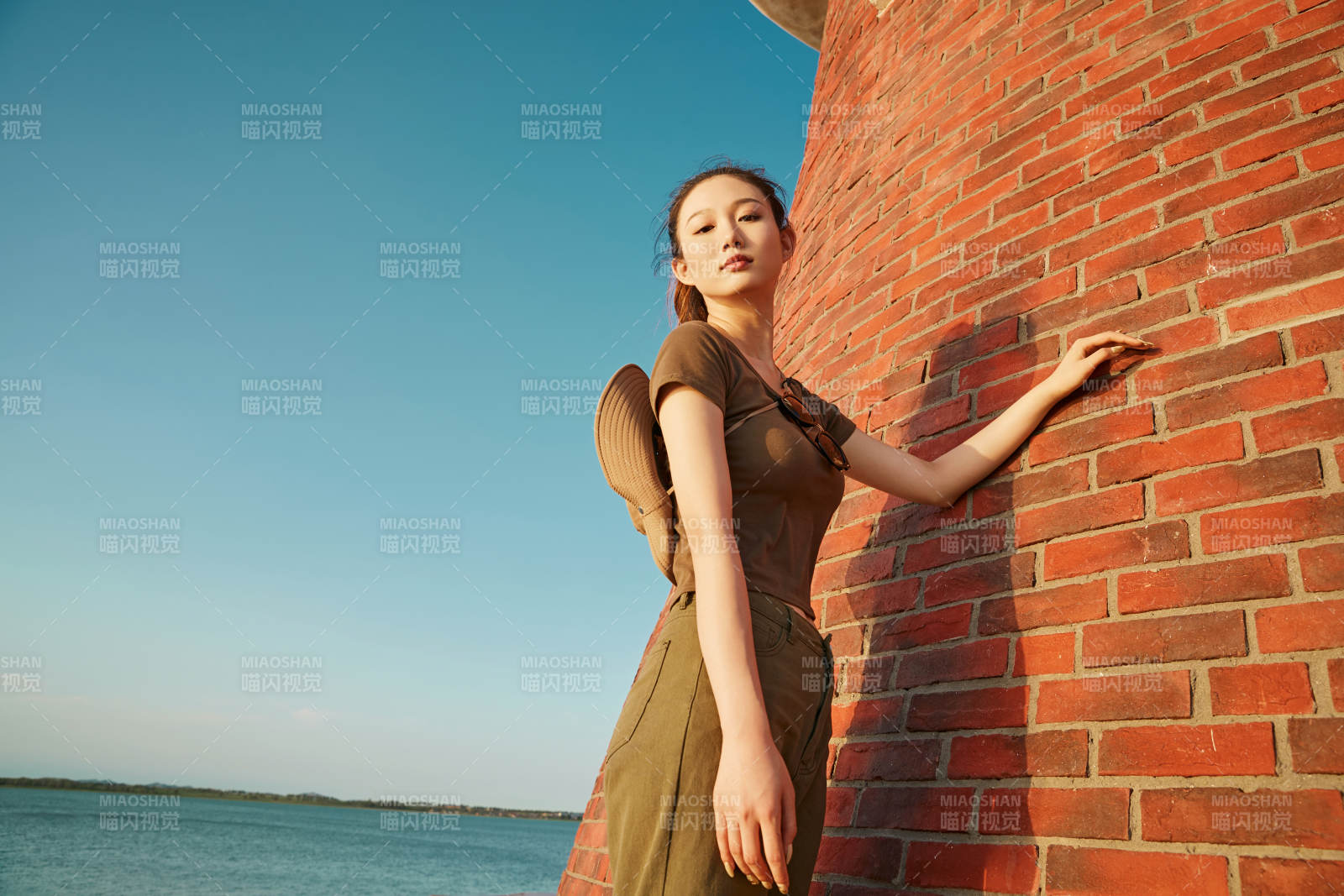 盛夏夕阳晚霞湖边码头灯塔上的少女图片