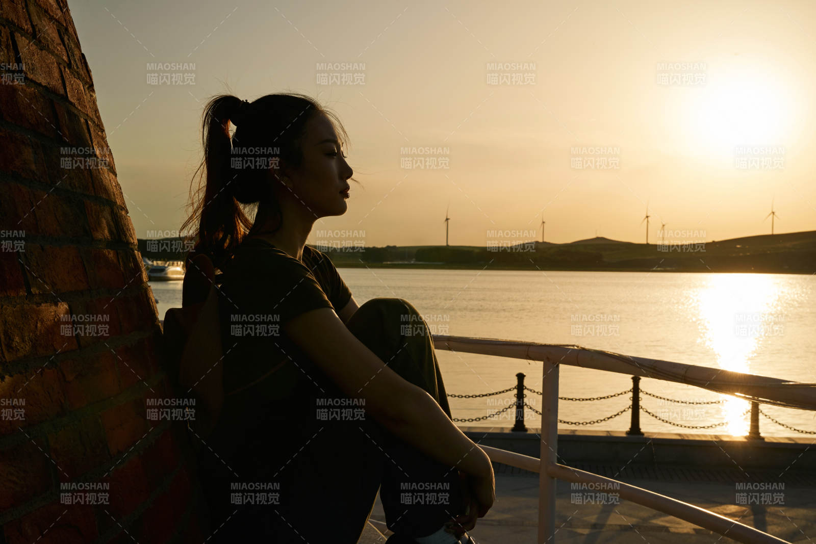 盛夏夕阳晚霞湖边码头灯塔上的少女图片