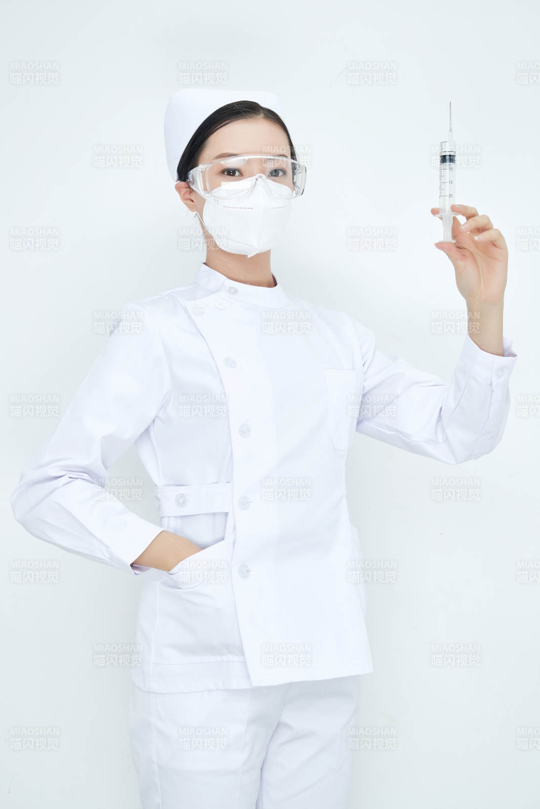 穿护士服戴口罩手执针筒的年轻女护士图片
