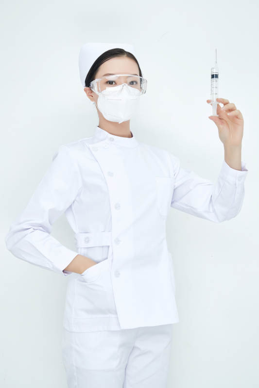 穿护士服戴口罩手执针筒的年轻女护士图片