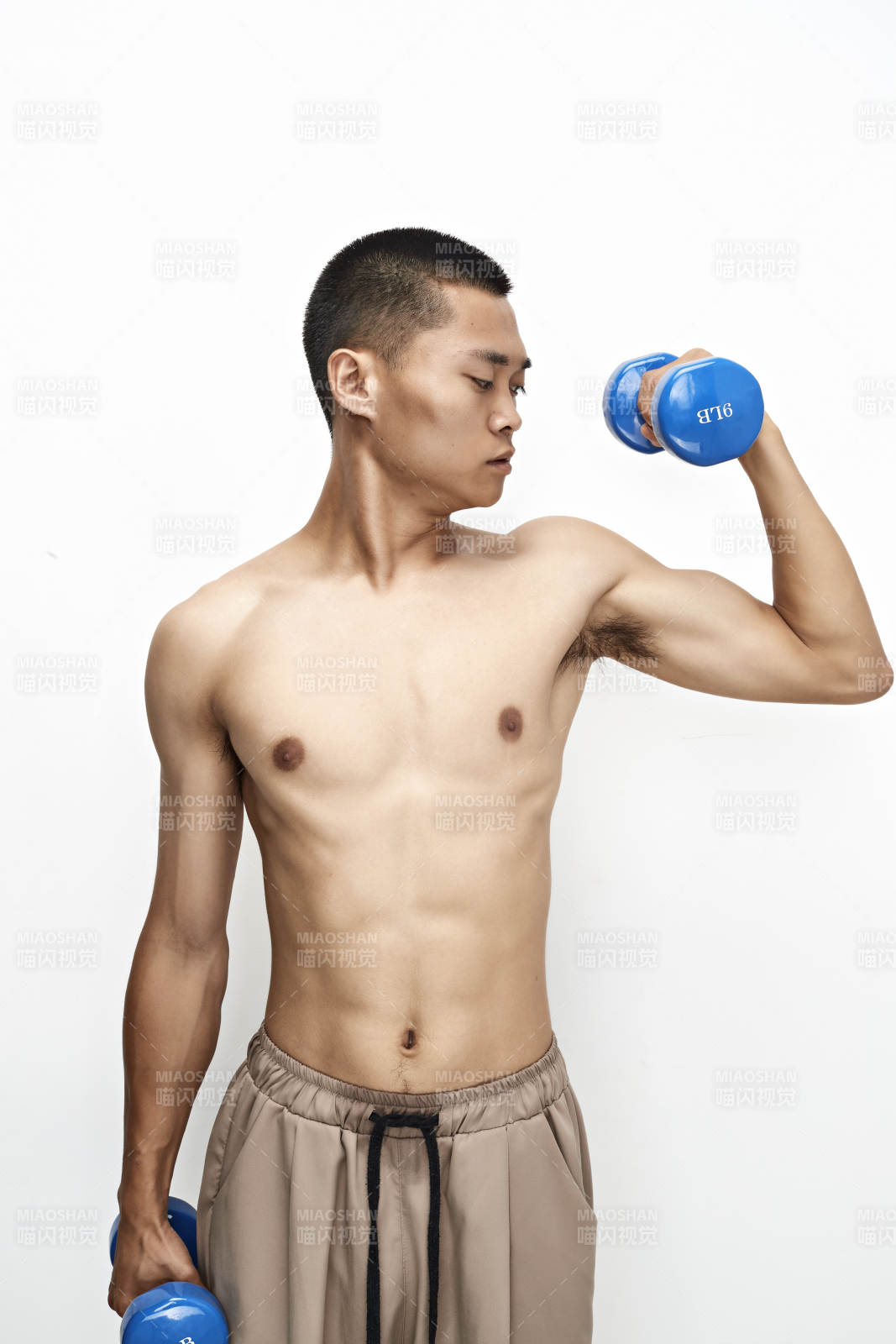 使用哑铃进行健身锻炼的亚洲男性图片