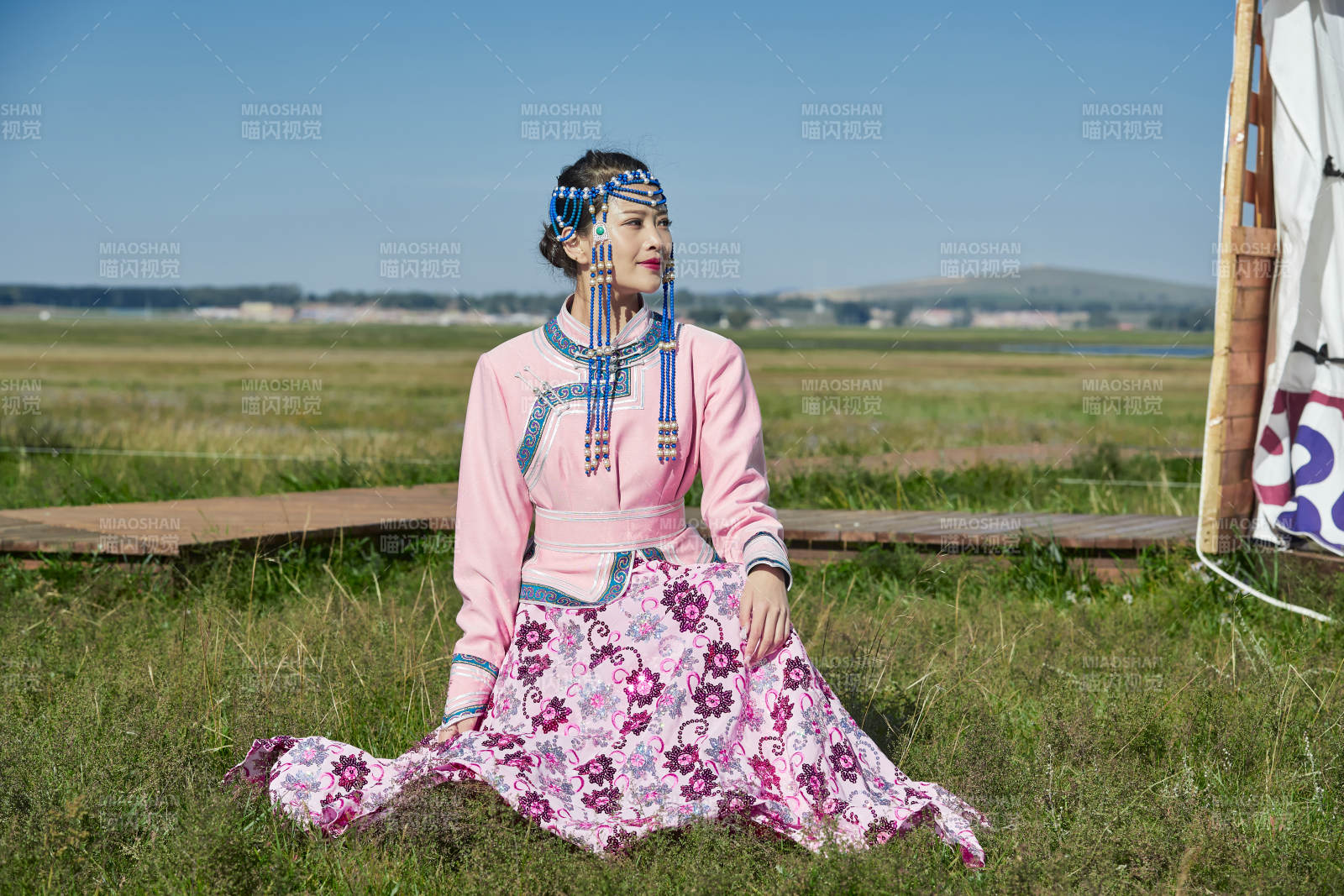 蒙古包前穿蒙古族饰怀抱奶茶桶的蒙族少女图片
