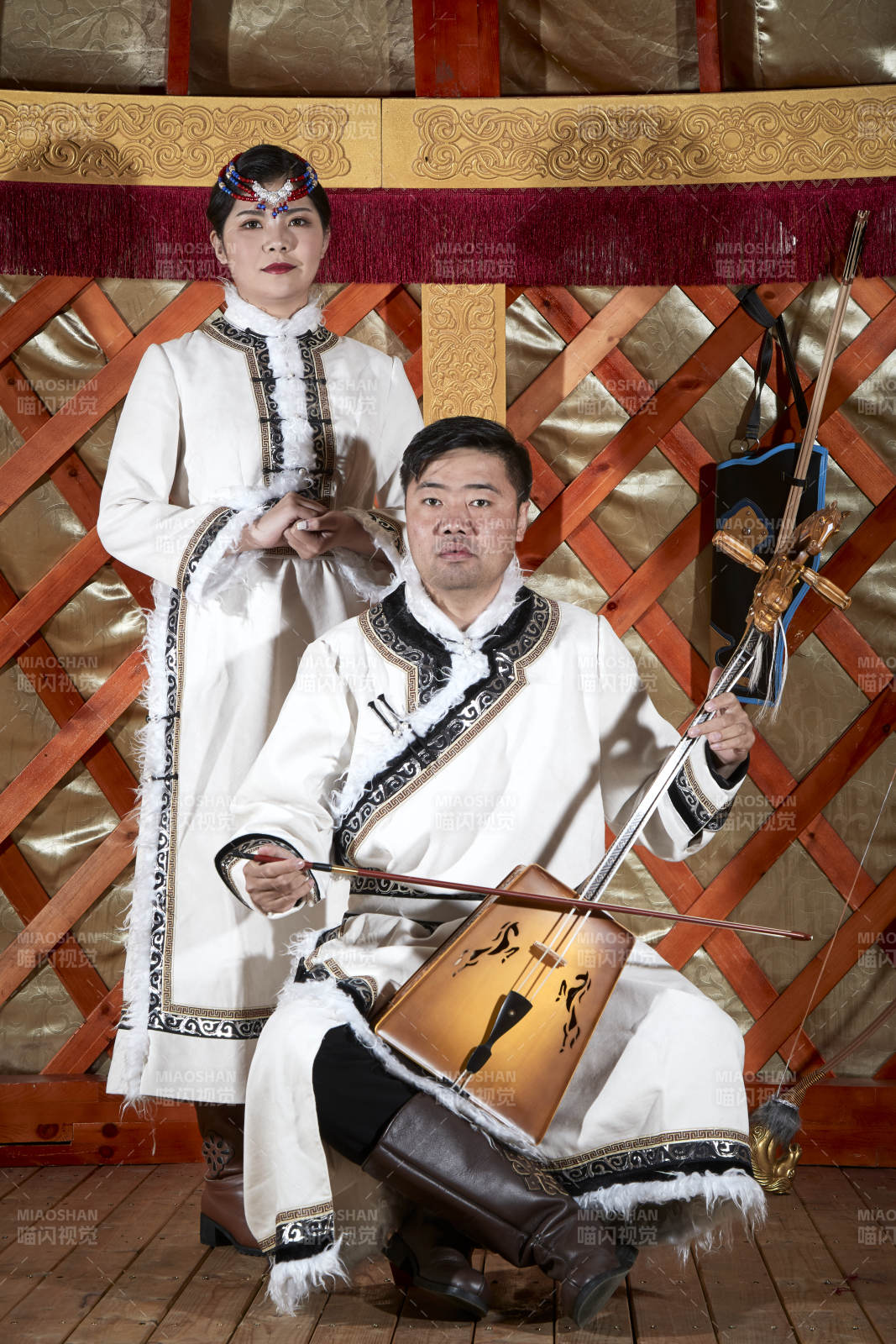 草原上蒙古包里穿蒙古族传统服饰的年轻夫妻图片