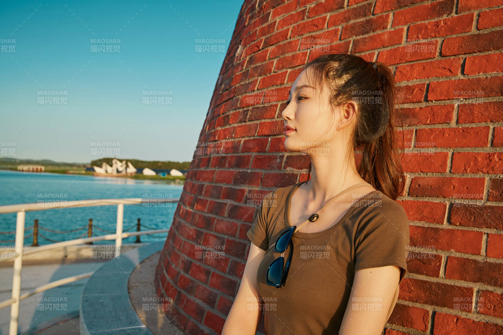 盛夏夕阳晚霞湖边码头灯塔上的少女图片