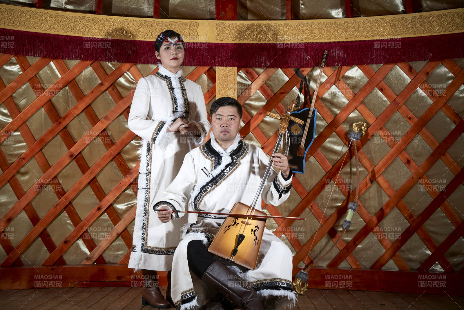 草原上蒙古包里穿蒙古族传统服饰的年轻夫妻图片