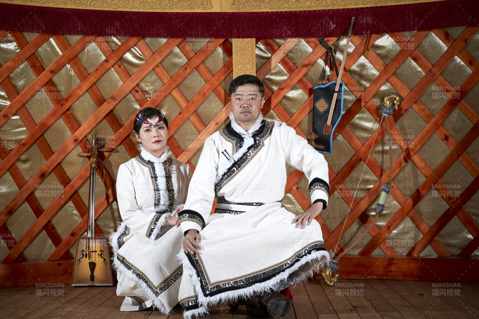 草原上蒙古包里穿蒙古族传统服饰的年轻夫妻图片