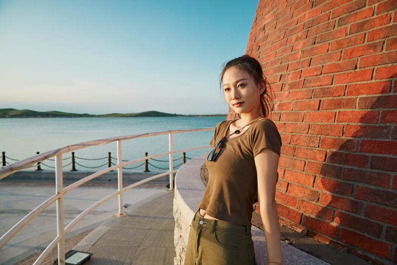 盛夏夕阳晚霞湖边码头灯塔上的少女图片