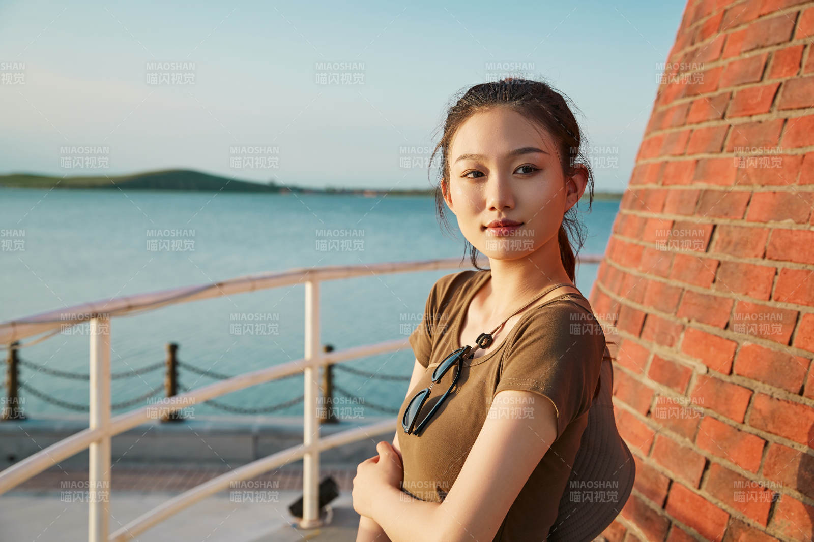 盛夏夕阳晚霞湖边码头灯塔上的少女图片