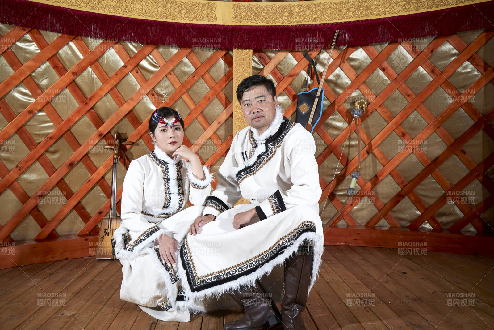 草原上蒙古包里穿蒙古族传统服饰的年轻夫妻图片