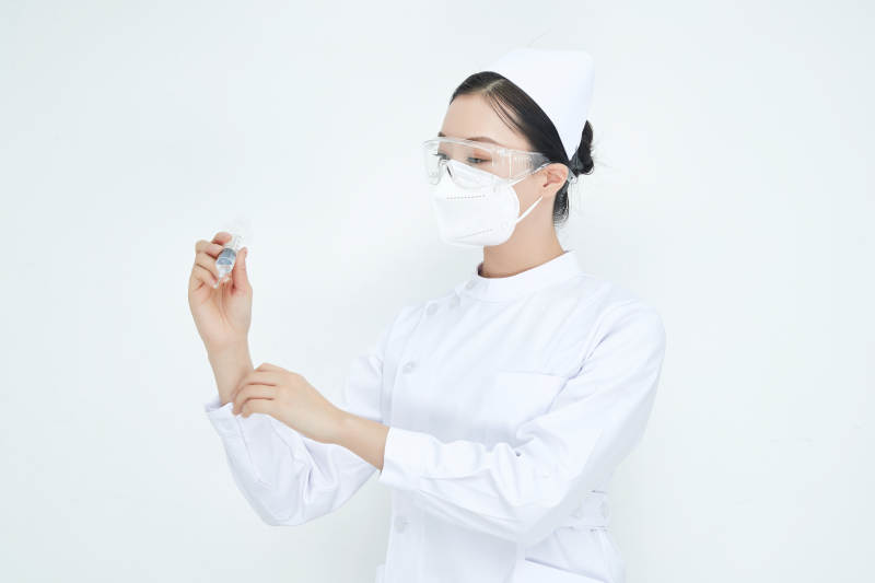 穿护士服戴口罩手执针筒的年轻女护士图片