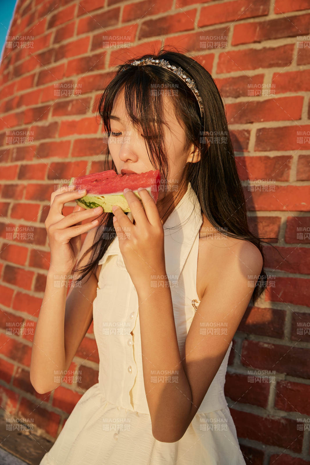 盛夏夕阳湖边码头灯塔上吃西瓜的少女图片