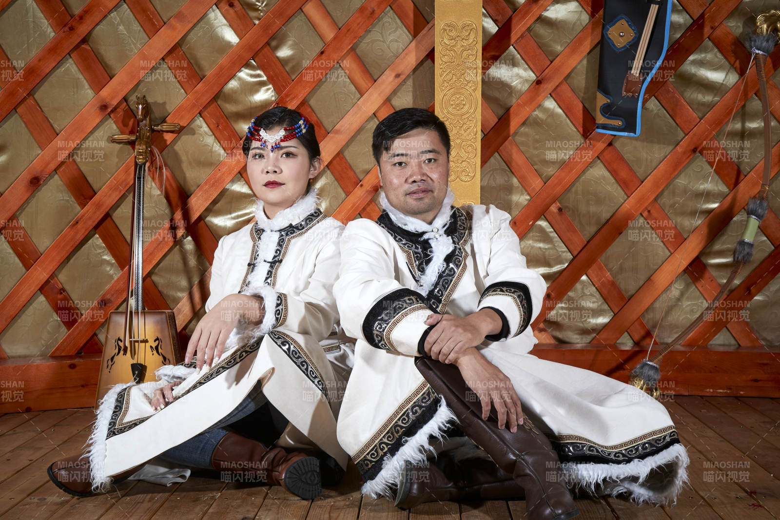 草原上蒙古包里穿蒙古族传统服饰的年轻夫妻图片