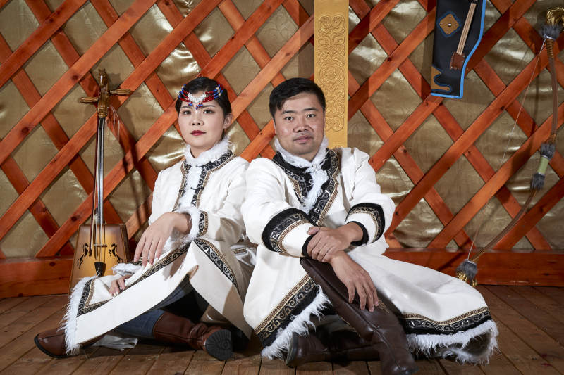 草原上蒙古包里穿蒙古族传统服饰的年轻夫妻图片