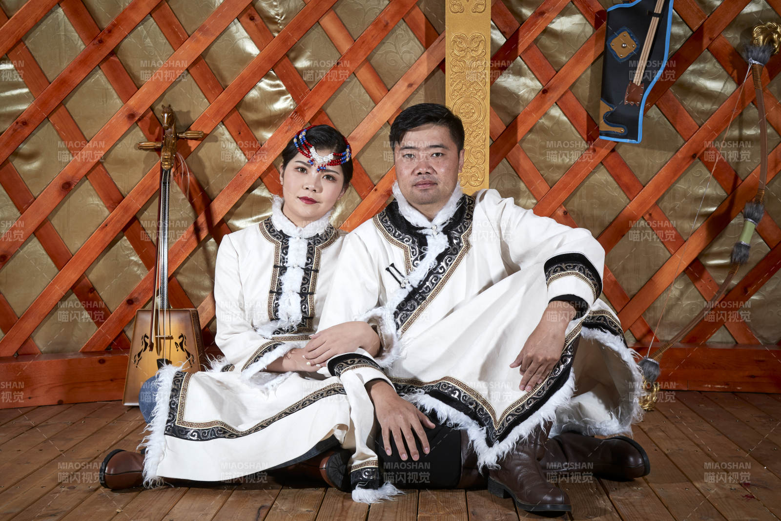 草原上蒙古包里穿蒙古族传统服饰的年轻夫妻图片