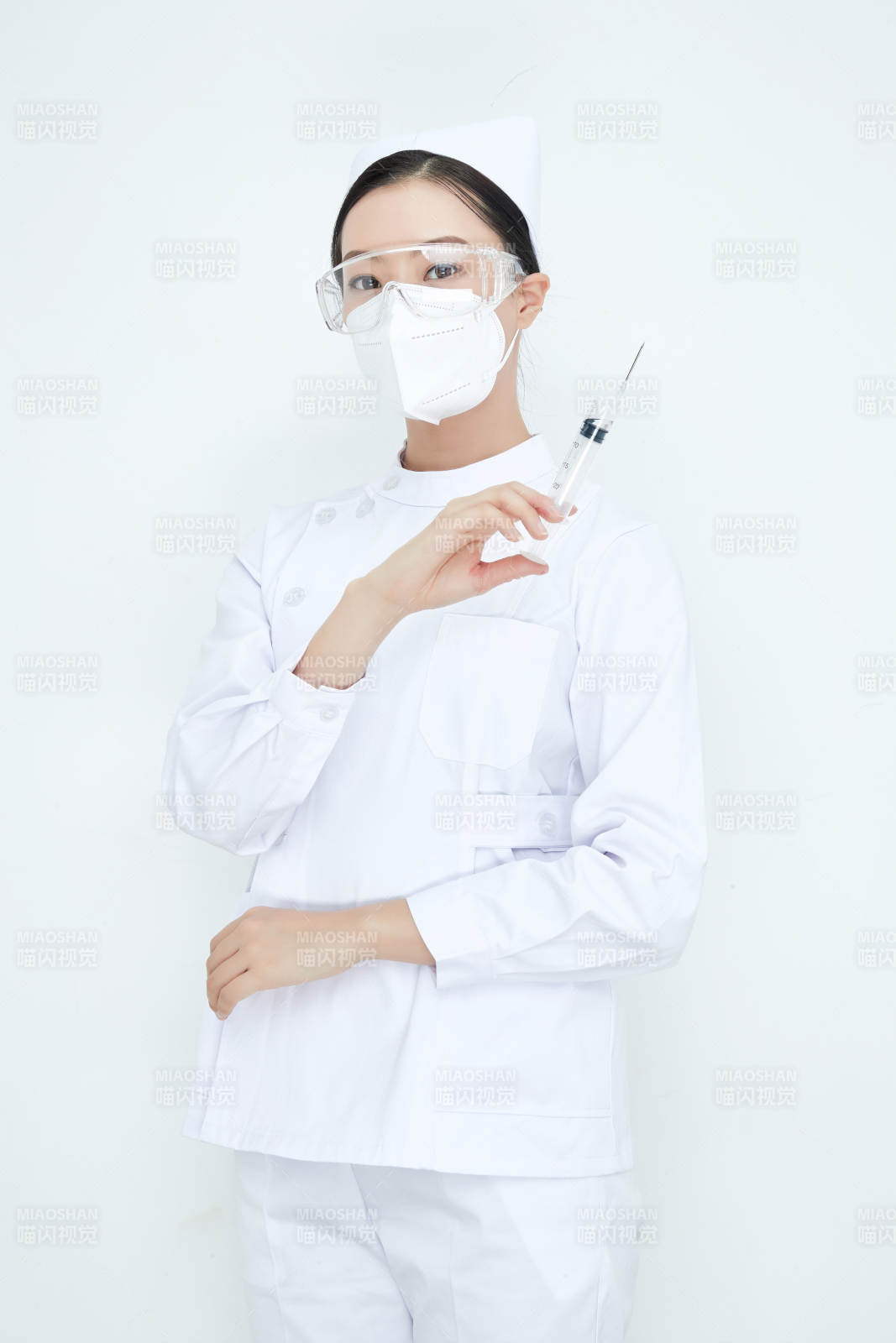穿护士服戴口罩手执针筒的年轻女护士图片