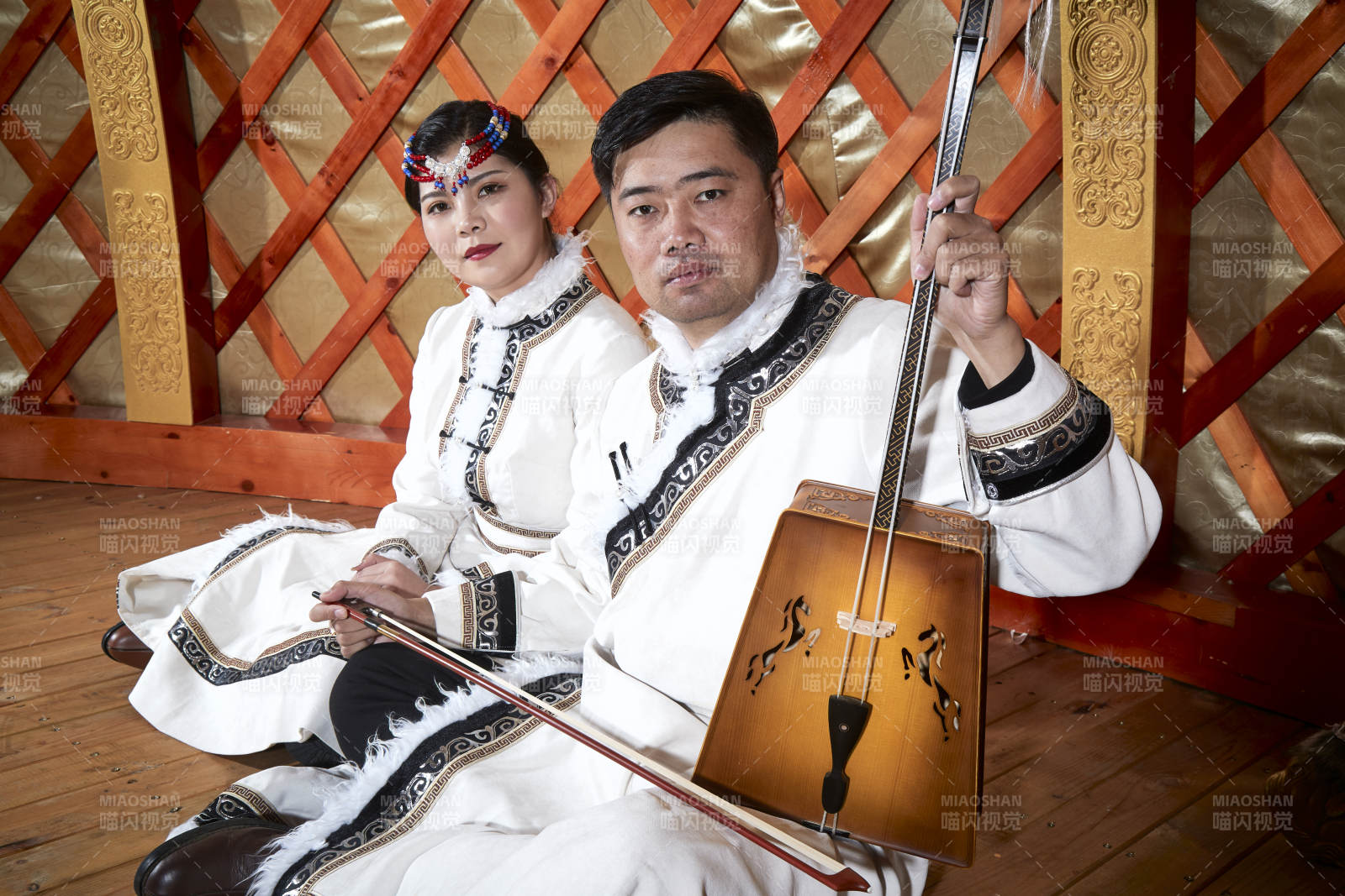 草原上蒙古包里穿蒙古族传统服饰的年轻夫妻图片