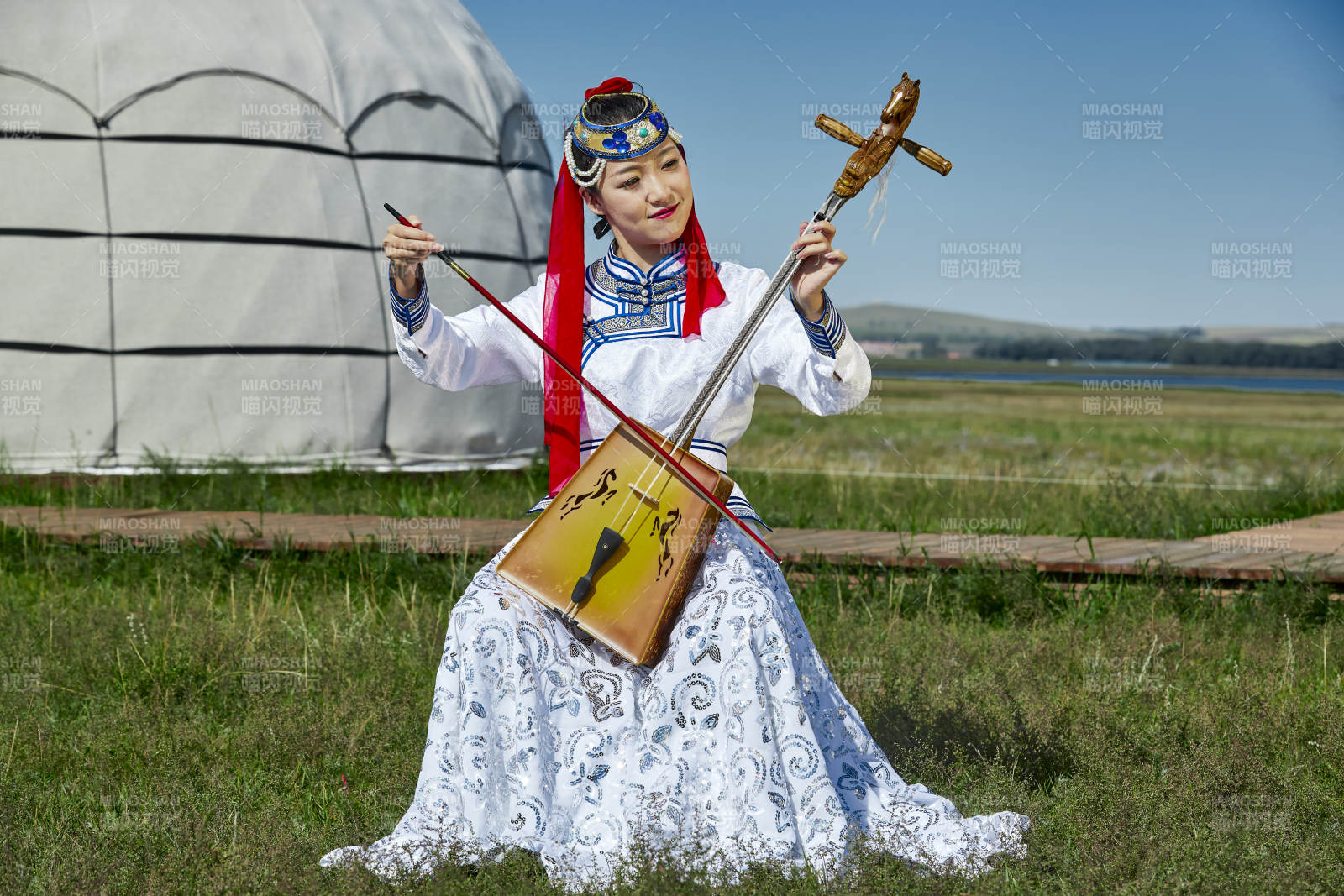 蒙古包前穿蒙古族服饰拉马头琴的蒙族女乐手图片