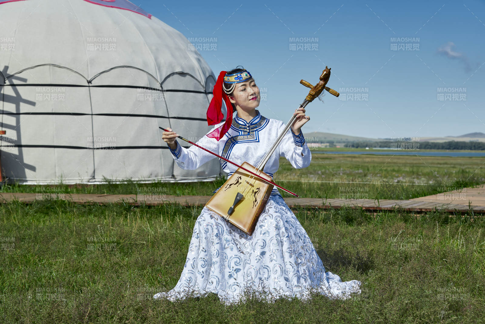 蒙古包前穿蒙古族服饰拉马头琴的蒙族女乐手图片