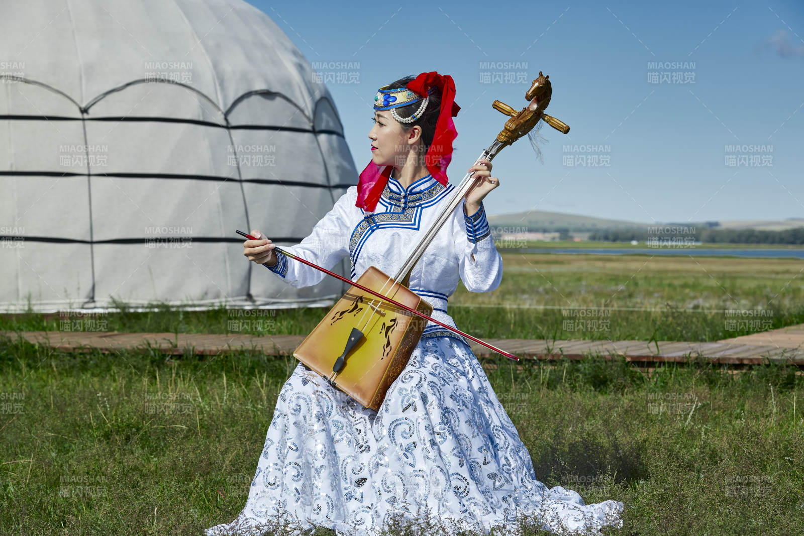 蒙古包前穿蒙古族服饰拉马头琴的蒙族女乐手图片