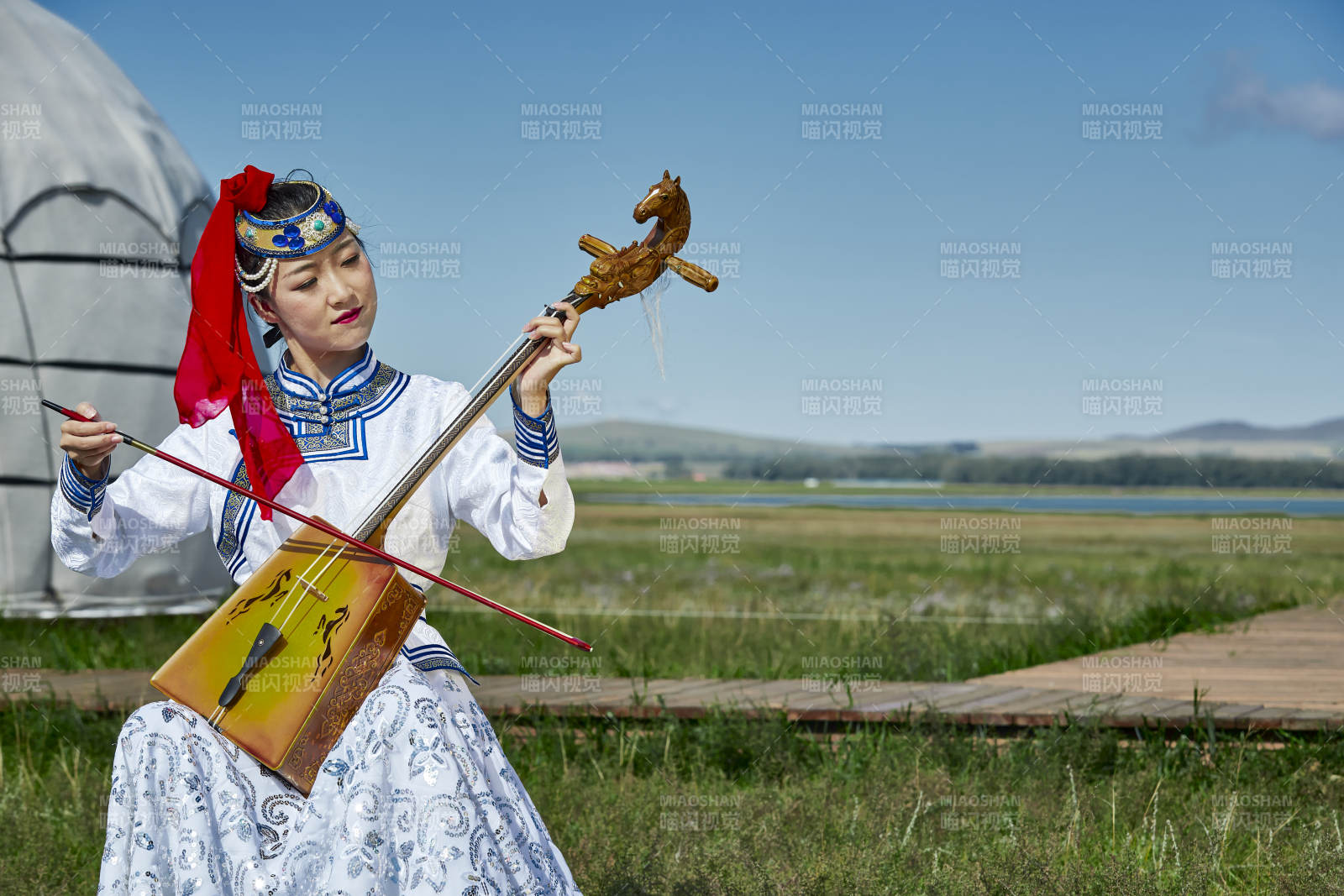 蒙古包前穿蒙古族服饰拉马头琴的蒙族女乐手图片