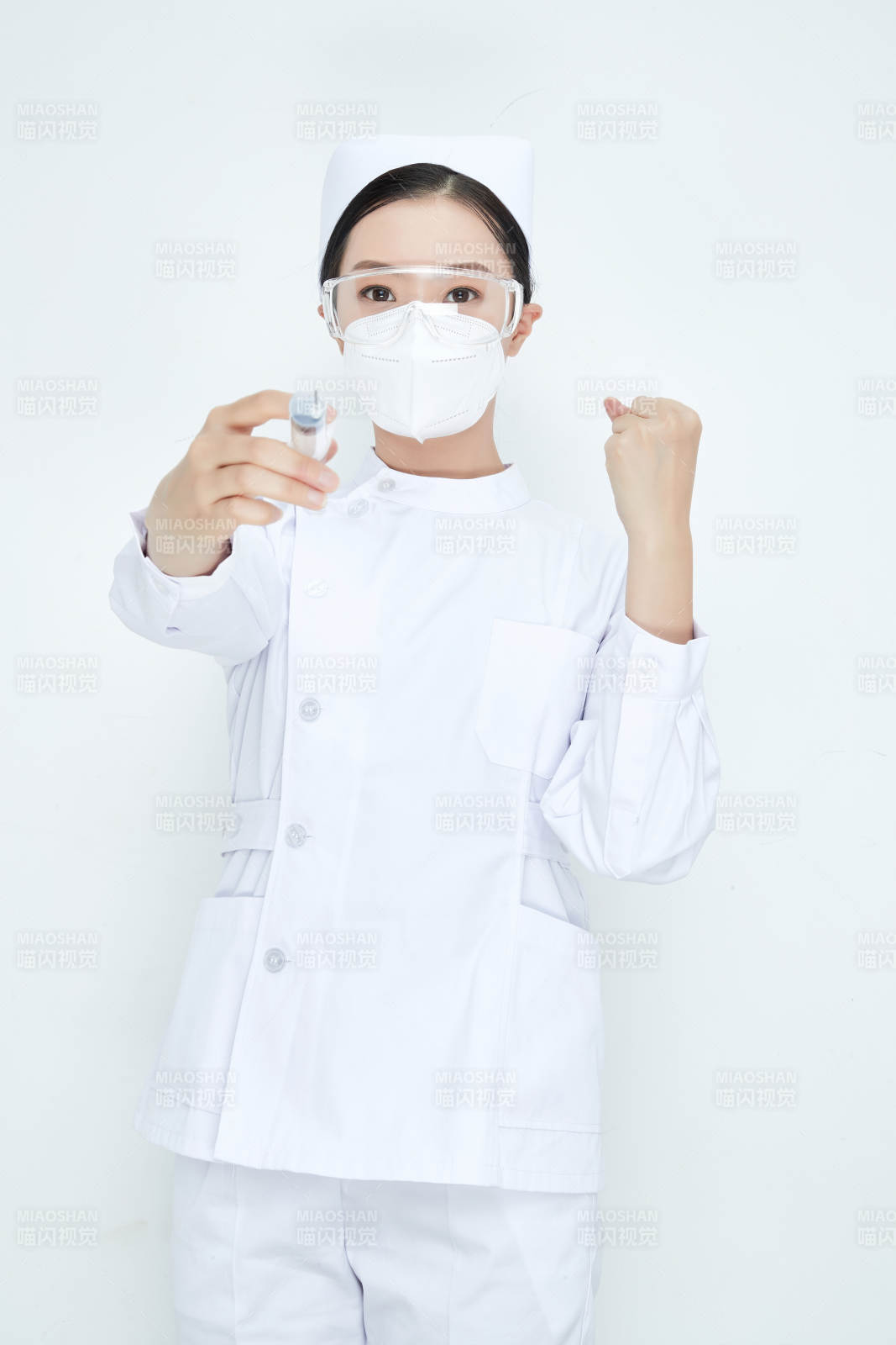 穿护士服戴口罩手执针筒的年轻女护士图片