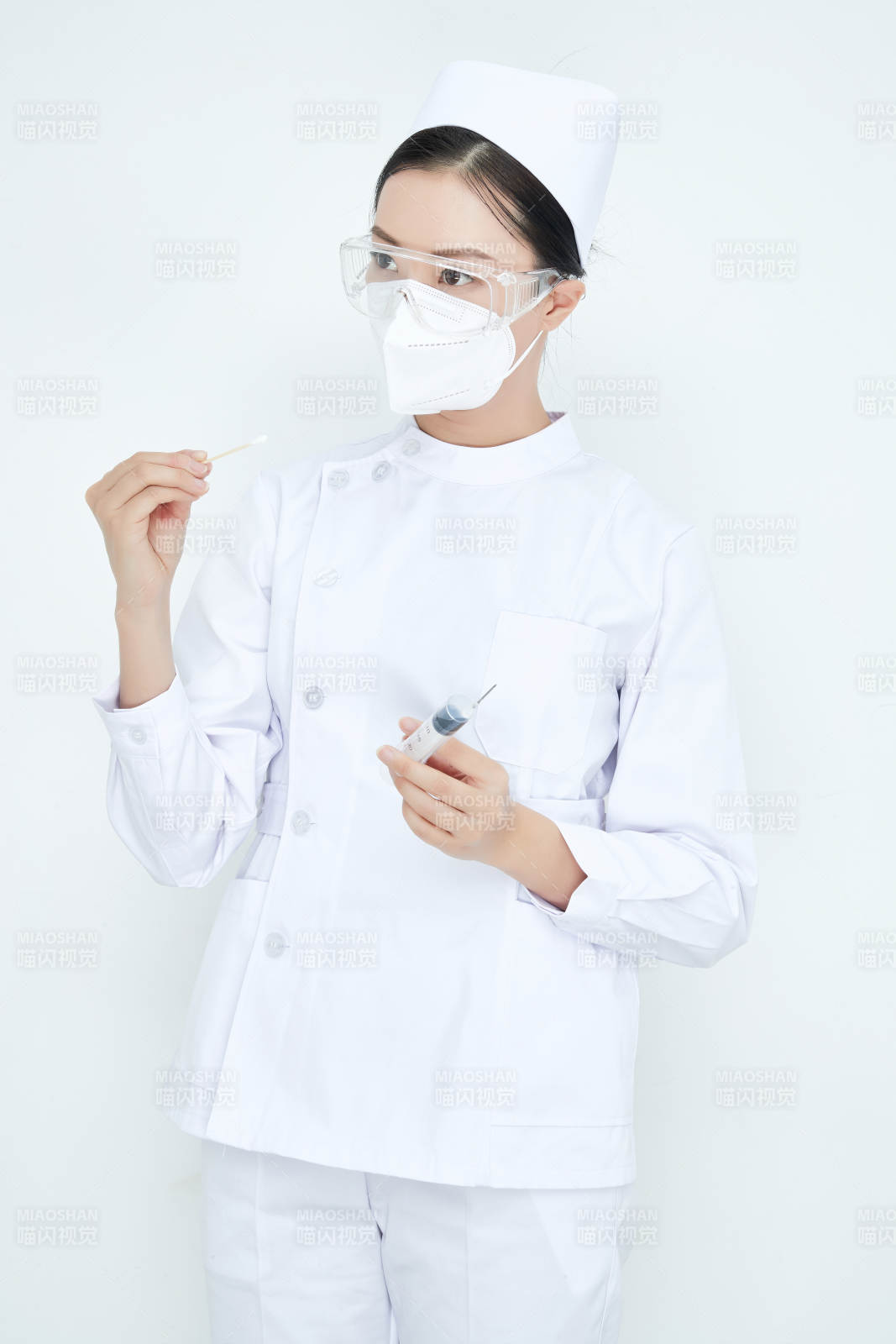 穿护士服戴口罩手执针筒的年轻女护士图片