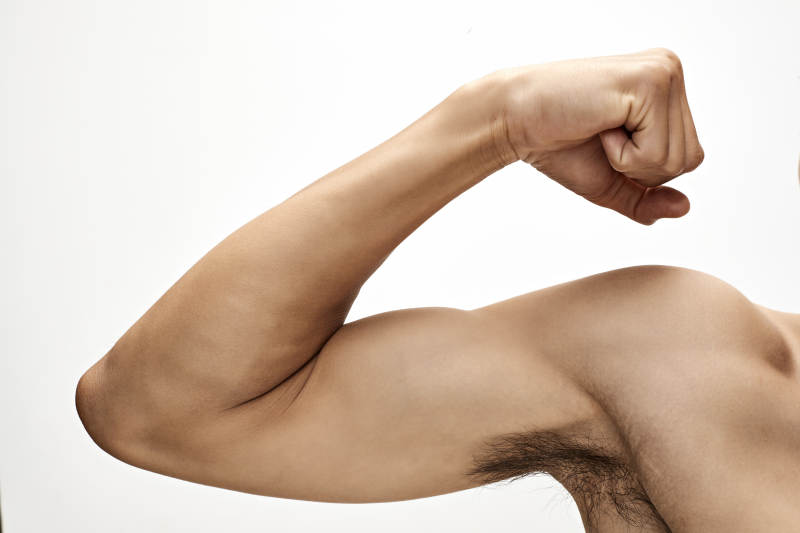 白色背景下展示肱二头肌的亚洲健身男性图片