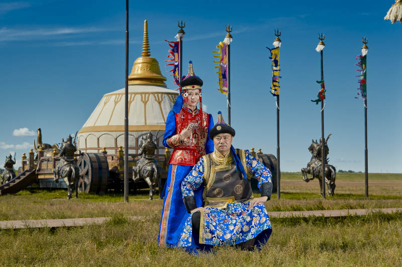 草原上蒙古包前穿蒙古族传统服饰的年轻夫妻图片
