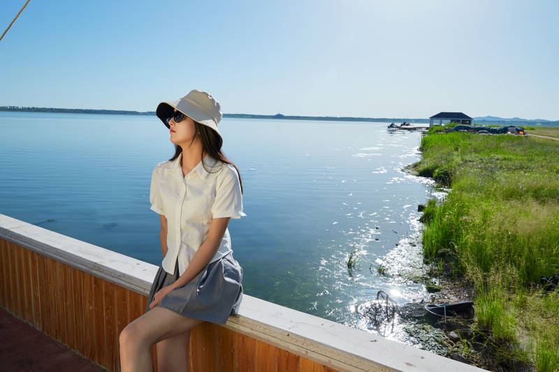 在湖畔木制帆船上的亚洲美女图片